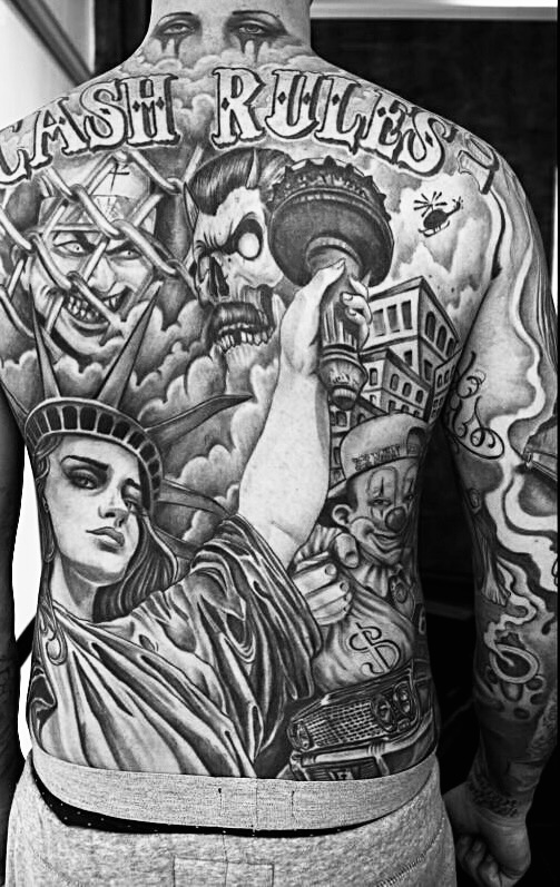 Tatuaggio chicano black and grey “Cash Rules” di Adriano El General con Statua della Libertà, clown e teschio