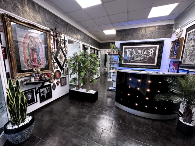 Mi Vida Loca Tattoo: dove tatuaggio e arte si incontrano Interno del Mi Vida Loca Tattoo Studio: ambiente artistico con opere originali, crocifissi antichi, maschere giapponesi e collezione privata di Adriano El General.